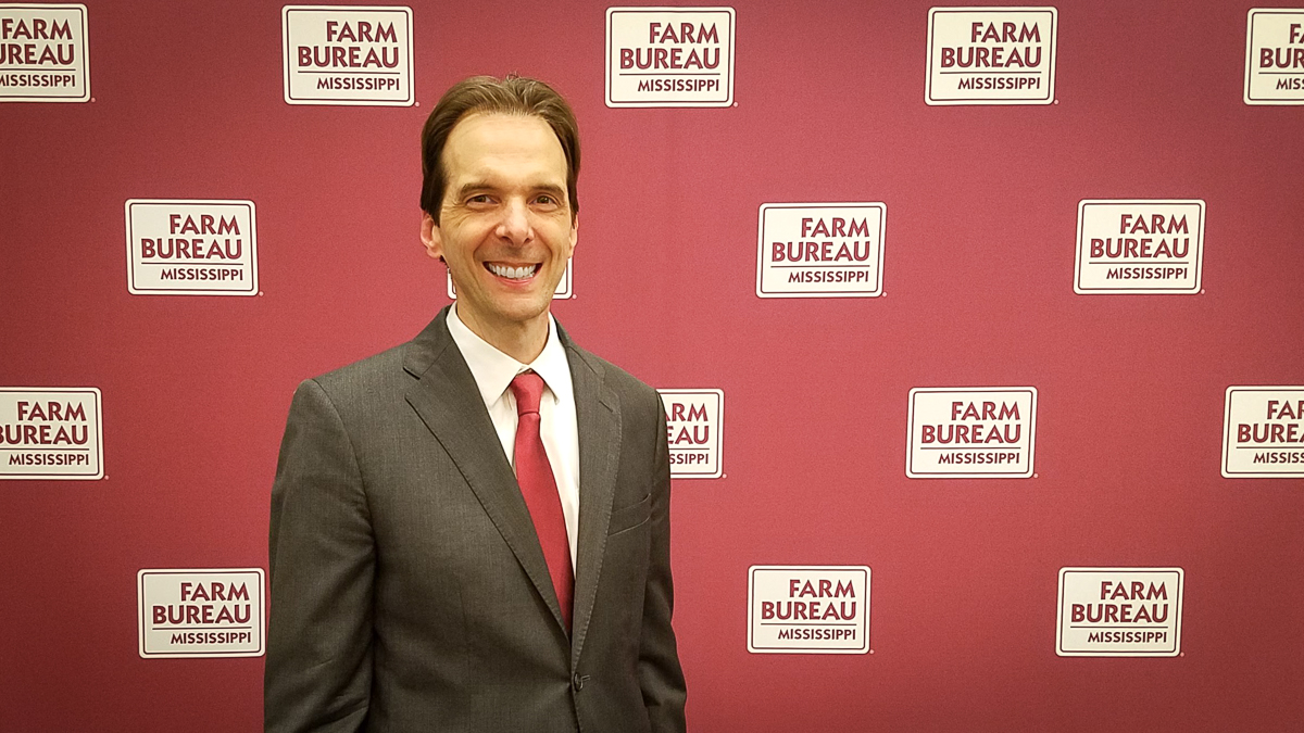 Motivational speaker Larry Weaver in front of a Mississippi Farm Bureau Federation backdrop in Jackson, Mississippi