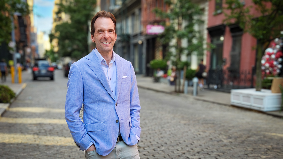 Motivational speaker Larry Weaver posing on a cobblestone street in SoHo, Lower Manhattan
