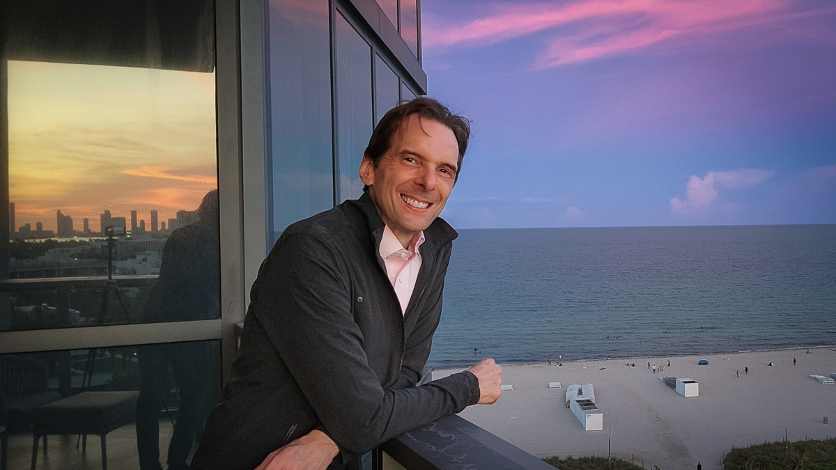 Motivational speaker Larry Weaver on a balcony overlooking South Beach in Miami at sunset