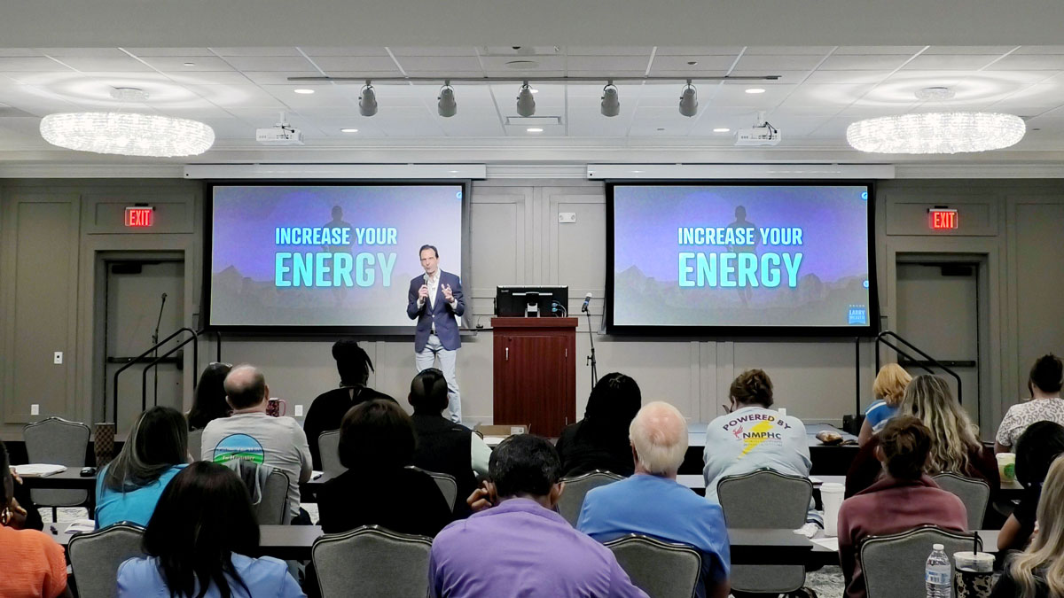 Larry Weaver speaking onstage for a community healthcare provider at Nunnally Center for Community Health Excellence in Ripley, Mississippi.