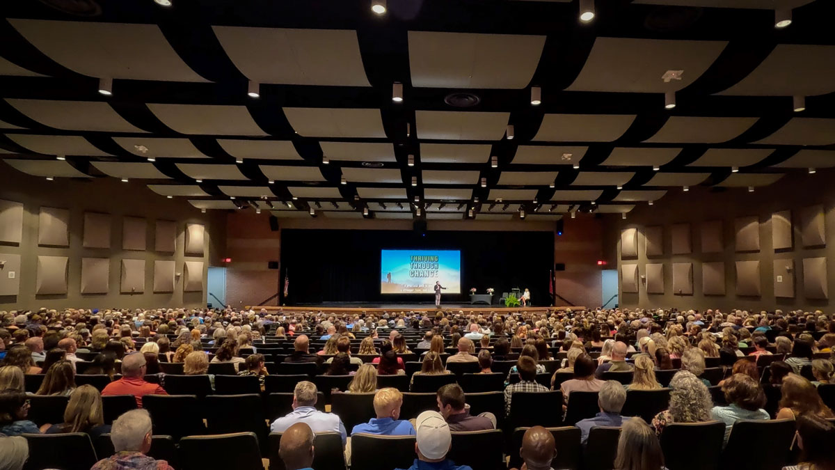 Larry Weaver speaking onstage for a crowd of 1,000 school district employees during a back-to-school staff convocation at Stone Memorial High School Auditorium in Crossville, Tennessee.