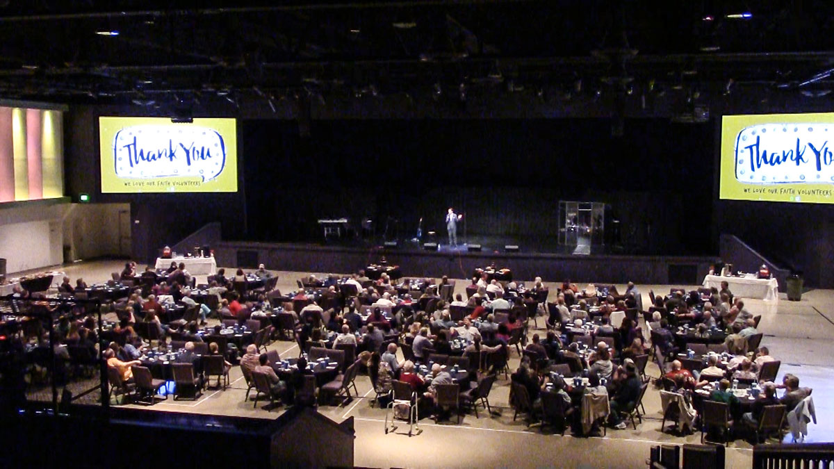 Motivational keynote speaker Larry Weaver addressing a large audience at a volunteer appreciation event in North Fort Myers, Florida